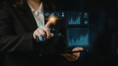 Businesswoman analyzes data on tablet with interactive digital interface displaying various...