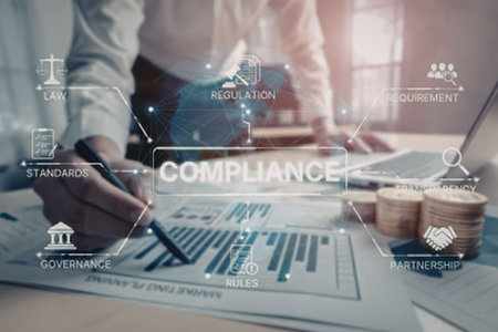 Business professionals review compliance documents and regulations together in a modern office...
