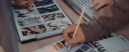 Creative professional working on graphic design project with color palette inspiration and laptop on...