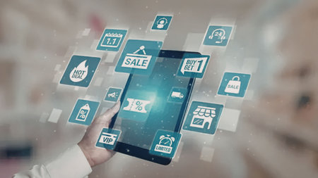 Hand holding digital tablet with e-commerce promotional icons and symbols for online shopping and...