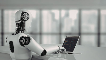 Humanoid robot sits at a desk using a laptop in a modern office with blurred city view outside large windows.の写真素材