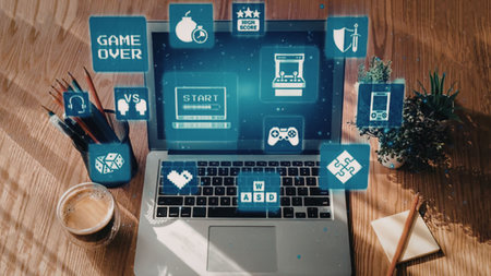 Laptop on a wooden desk displays various white gaming icons on a blue screen surrounded by office...