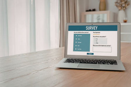 Laptop on wooden table displays online customer satisfaction survey form with rating options and...