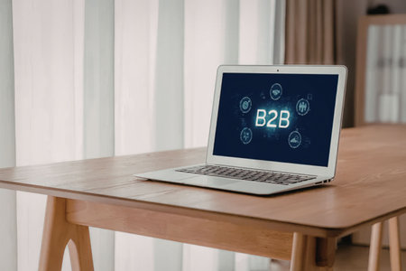 Laptop displays business to business technology on a blue screen while sitting on a wooden office...