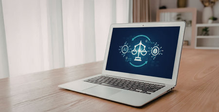 Modern laptop on a wooden desk displays a digital scale icon symbolizing justice and balance in...