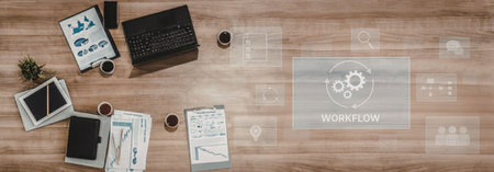 Modern office workspace setup with laptop, documents, and workflow management tools on a wooden desk...