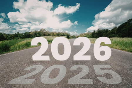 Empty road with green grass on both sides symbolizing transition from 2025 to 2026 with reflection...