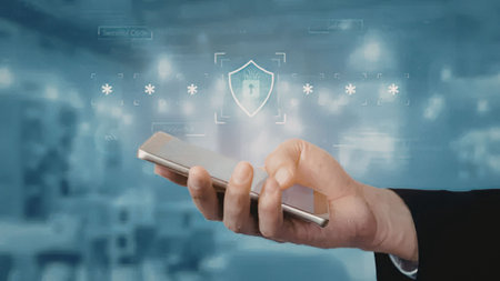 Person holds smartphone with digital shield and lock symbolizing cybersecurity and data protection...