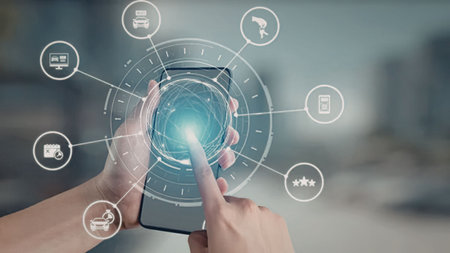 Person interacts with smartphone displaying a futuristic digital interface with various icons and...