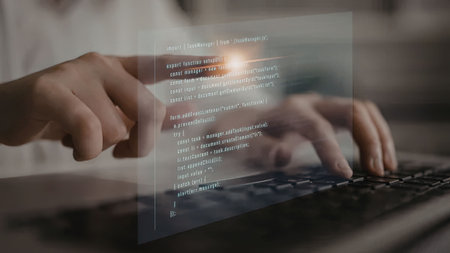 Software developer interacts with a virtual coding interface on a laptop with a transparent code...