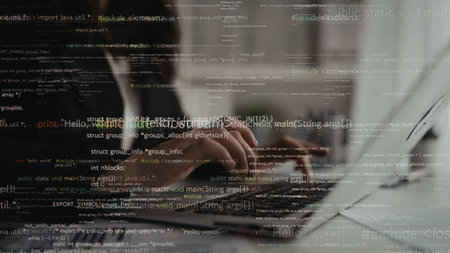 Software developer typing on laptop keyboard with code overlay displayed on the screen, representing...