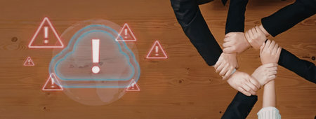 Team members put their hands together in a symbol of unity against a backdrop of cloud computing...