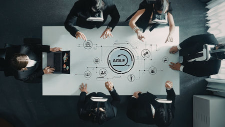 Professionals in business attire collaborate around a table with an agile methodology diagram...
