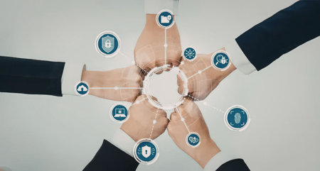 A group of business people joining hands in a circle, symbolizing partnership and teamwork, with...