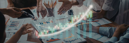 a group of people are gathered around a table looking at a graph with a green and blue line going...