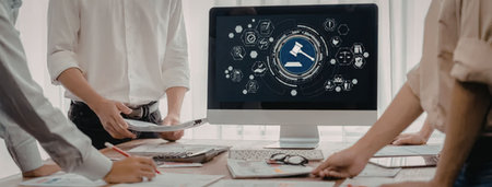 a group of people are gathered around a table looking at a computer screen with a blue and white...
