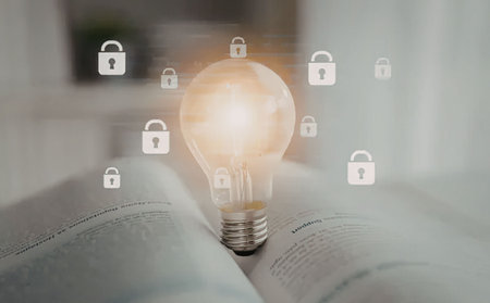 a glowing light bulb sits atop an open book with several white padlock icons floating above it in a...