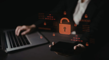a person sitting at a desk using a laptop with a large red padlock on the screen, symbolizing...