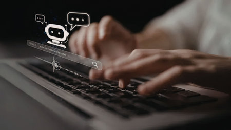 a close-up of a person's hands typing on a laptop keyboard with a chatbot interface overlaid on the...
