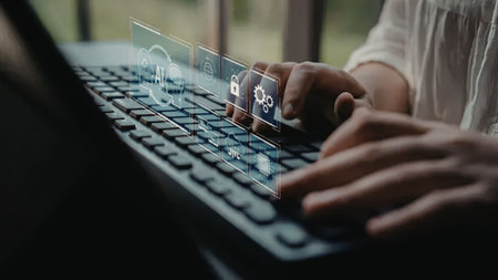 a person is typing on a laptop keyboard with a transparent interface hovering above