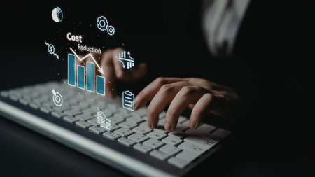 a close-up of a person's hands on a keyboard with a cost reduction graph and icons floating above...