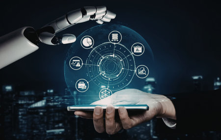 A robotic hand and a human hand holding a tablet with futuristic icons floating above it.