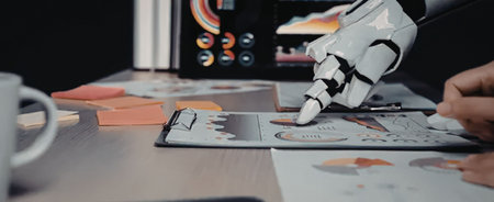 A robotic hand interacting with a digital tablet on a cluttered desk with various papers, graphs, and a coffee mug.の写真素材