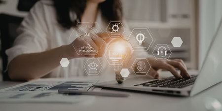A woman sitting at a desk, using a laptop with various business icons floating above the keyboard.