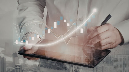 Business professional analyzes financial data on tablet with digital graph projections and...