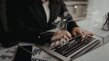 Business professional interacts with futuristic interface on laptop displaying graphs and charts,...