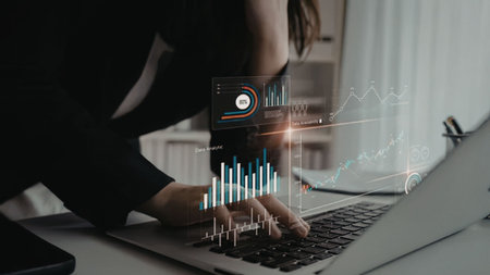 Business professional analyzing interactive 3D data visualizations and graphs on a modern laptop...
