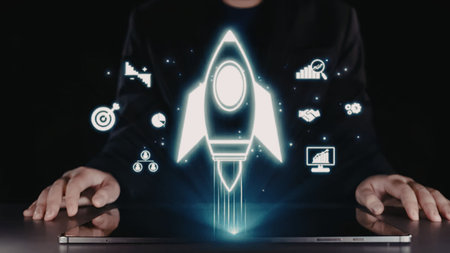 Person using laptop with glowing rocket ship symbolizing startup launch and business success with...