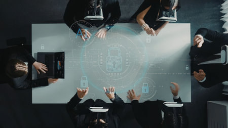 an overhead view of a group of businesspeople in black clothing sitting around a large rectangular...