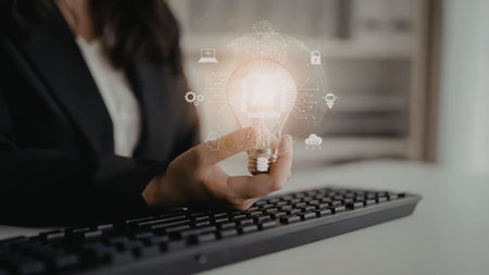 Businesswoman holds a glowing light bulb surrounded by innovative icons symbolizing creativity and...