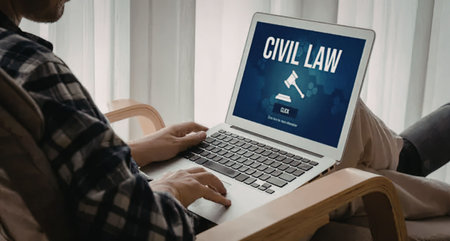 Man sitting comfortably in a chair browsing civil law information on his laptop computer with a...
