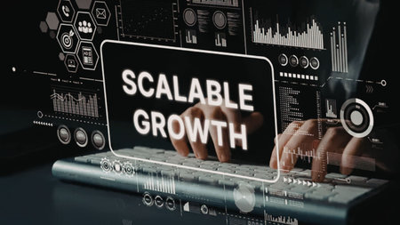 Person works on laptop with scalable growth on screen surrounded by various business analytics and...