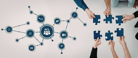 Multiple hands from different individuals come together, holding blue puzzle pieces, symbolizing...