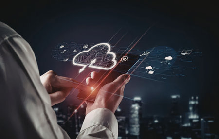 Man holds a mobile device displaying a glowing cloud symbol surrounded by digital elements against a...