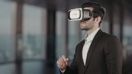 Businessman wearing virtual reality headset interacts with digital information in a modern office...