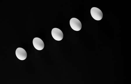 Five easter white eggs on black background.の写真素材