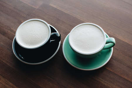 A cup of raf coffee on wooden background. Black and greenary ceramic cups.