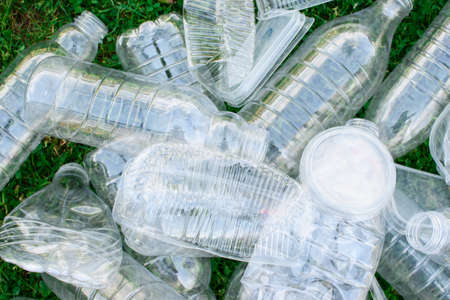Pile of used plastic bottles on the grass, the concept of ecology. Waste separation concept.の写真素材