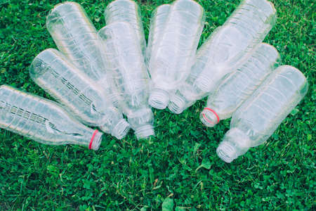 Pile of used plastic bottles on the grass, the concept of ecology. Waste separation concept.の写真素材