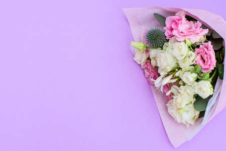 Colorful beautiful bouquet of different fresh flowers on the violet background. Floral arrangement....