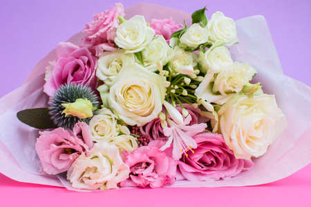 Colorful beautiful bouquet of different fresh flowers on the pink-violet background. Floral arrangement. Close up.の写真素材