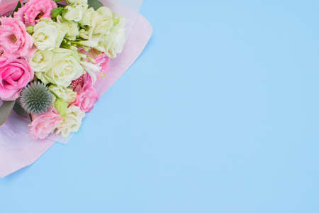 Colorful beautiful bouquet of different fresh flowers on the light blue background. Floral arrangement. Close up.の写真素材