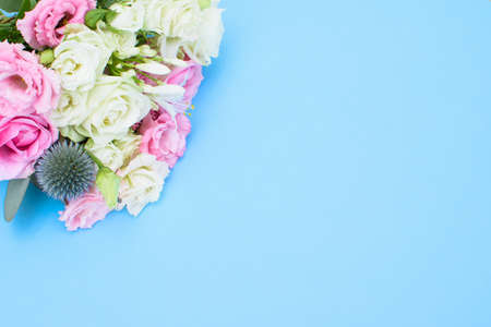 Colorful beautiful bouquet of different fresh flowers on the light blue background. Floral arrangement. Close up.の写真素材