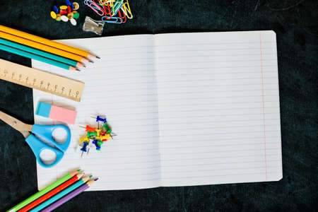 Office and school supplies on black board background with copy space. Back to school concept. Flat lay.の写真素材