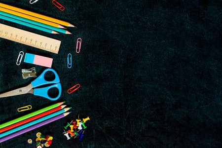 Office and school supplies on black board background with copy space. Back to school concept. Flat lay.の写真素材