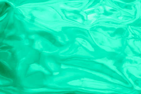 Holographic wrinkled abstract foil texture. Glittering blurred surface pack. Green mint bright...